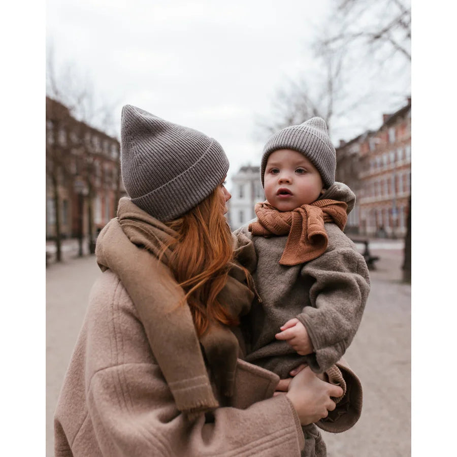 Frau hält ein Kind im Freien in Winterkleidung mit dem Adult Beanie Fonzie von Otter