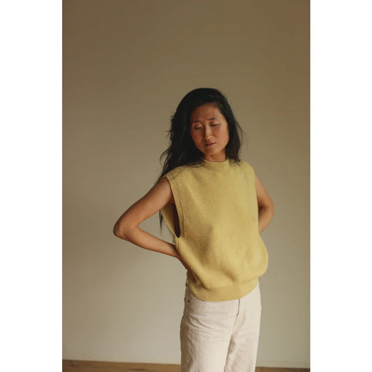 Frau trägt Pastellgelbes ärmelloses Stricktop und helle Hosen im Produkt Adult Vest Helle