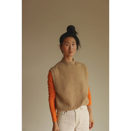 Eastasiatische Frau mit dunklem Haar in einem Sandfarbenen Erwachsenenweste Helle