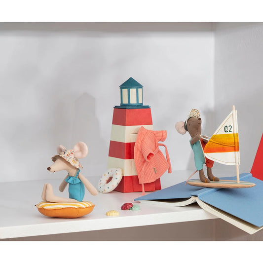 Roter und weißer gestreifter Leuchtturm mit tealfarbenem Dach und Spielzeugfiguren