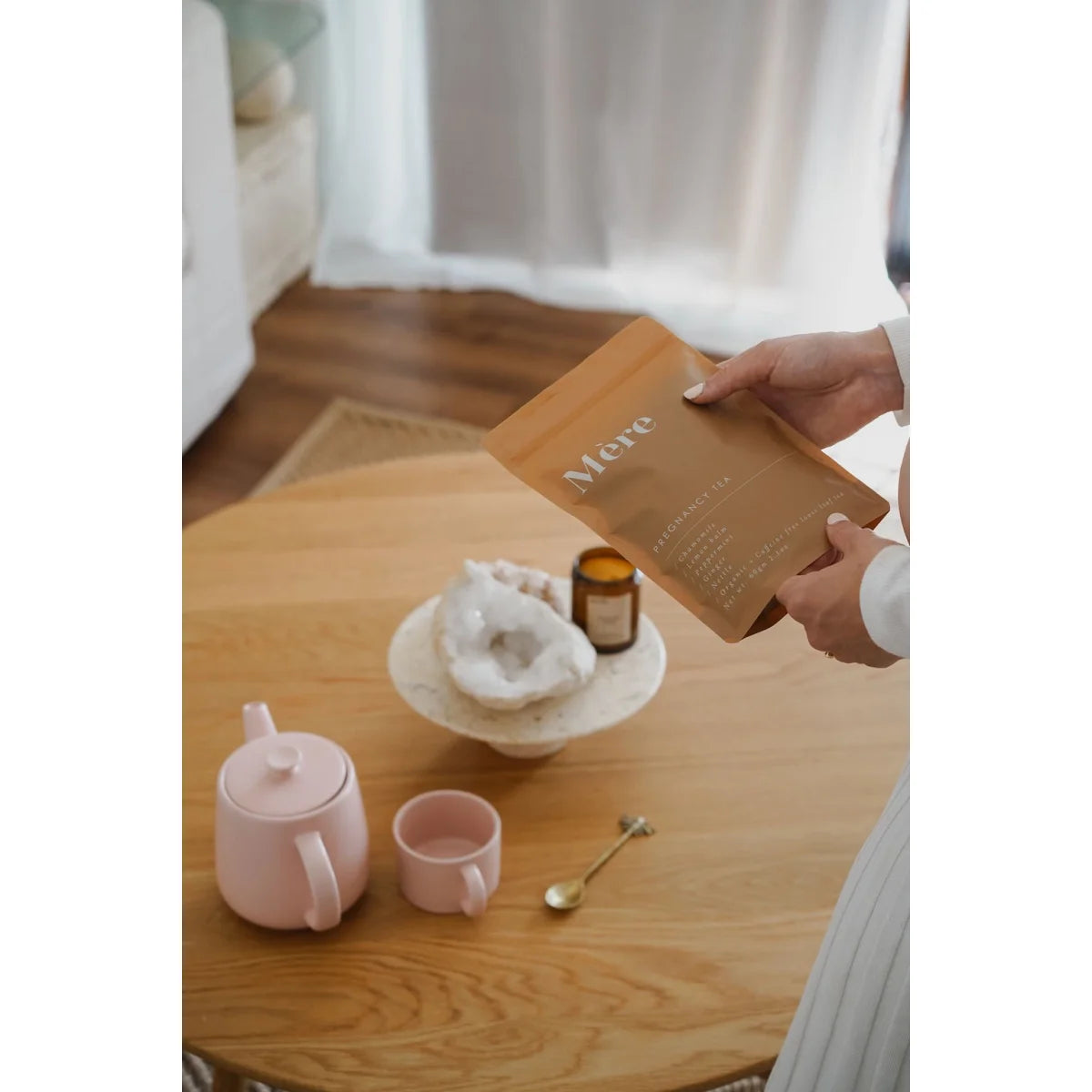 Hände halten einen goldenen Umschlag mit der Aufschrift Mom für Badesalz Postpartum