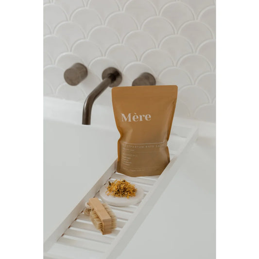 Goldfarbener Beutel mit Mère auf einem weißen Tablett neben Lebensmittelartikeln