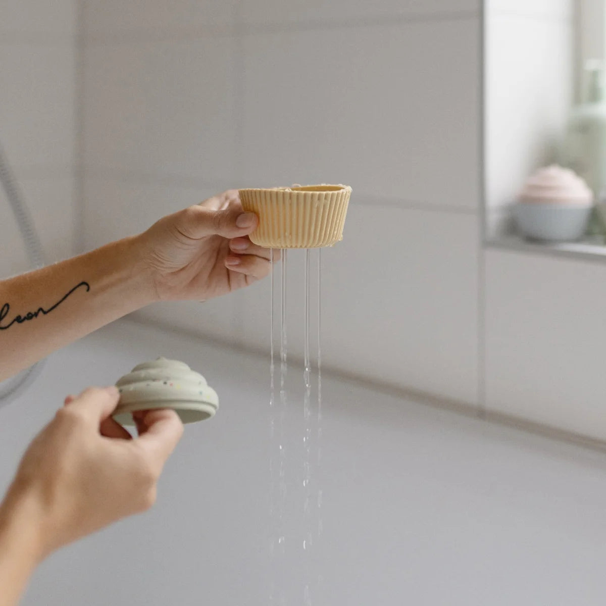 Gelber Cupcake-Liner mit Wasser, präsentiert im Badespielzeug Cupcake