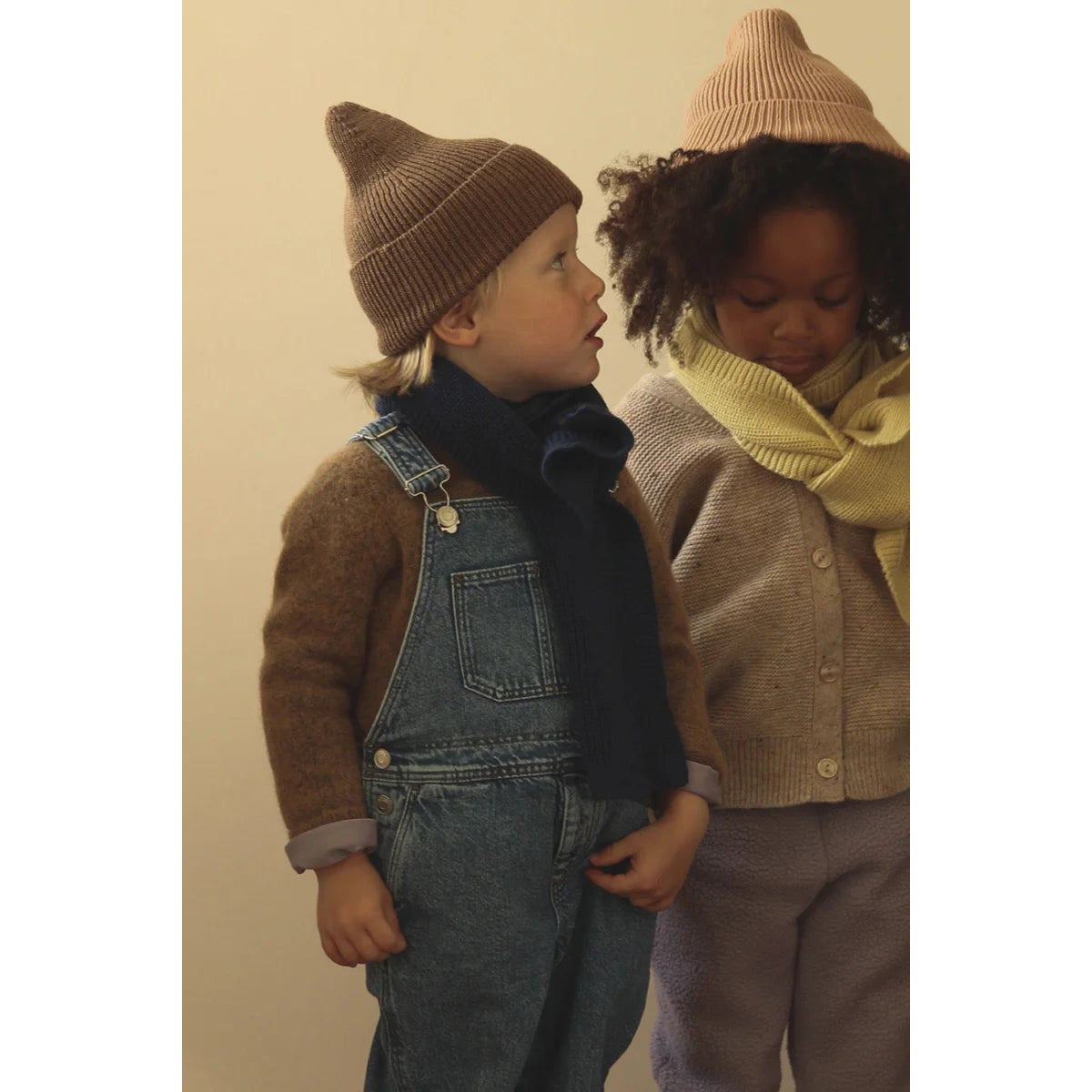 Zwei Kinder in Winterkleidung zeigen Beanie Fonzie in Mocha