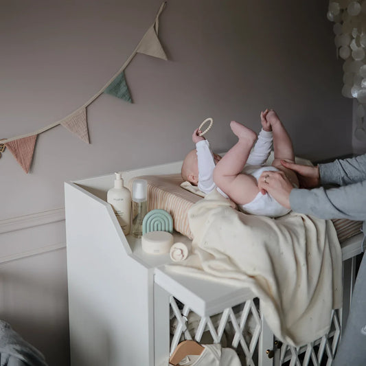 Weißes Holz-Wickelkommode mit Gitter und Beige-Decke, Beissring Perlenarmband im Design Leinen/Pfingstrose/Hellrosa