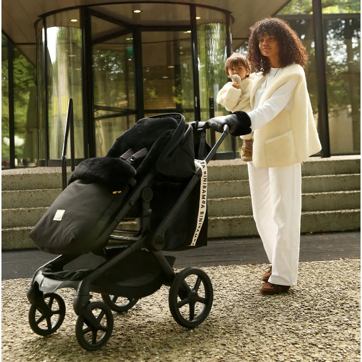 Schwarzer Kinderwagen mit Bassinet und Fußsack, inklusive feinstem Merino-Schafsfell