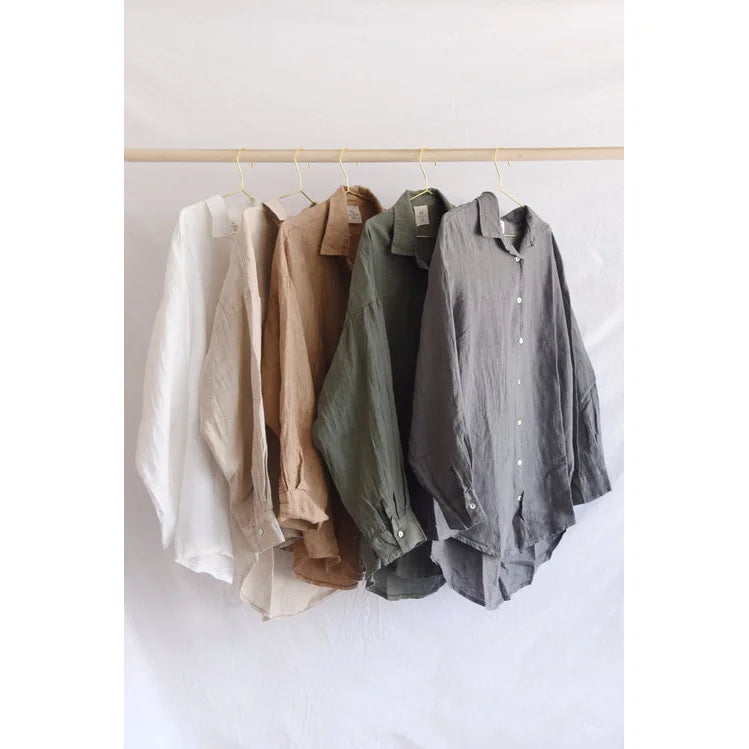 Button-down shirts in neutral colors on a rack for Bluse Palma | Fern