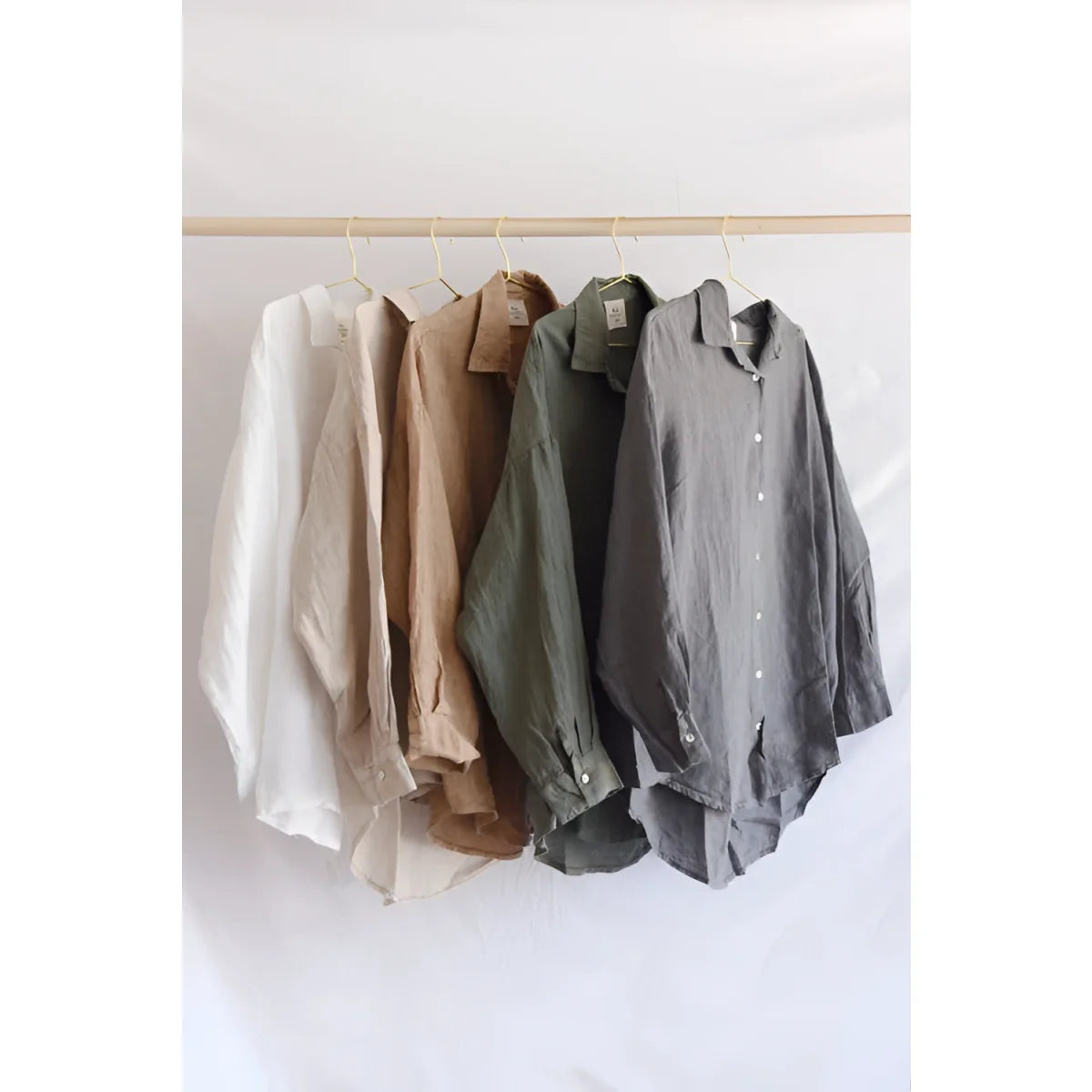Button-down shirts in neutral colors on a rack for Bluse Palma | Fern