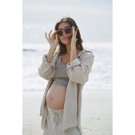 Schwangere Frau mit Sonnenbrille und hellfarbigem Outfit am Strand in Bluse Palma | Moon