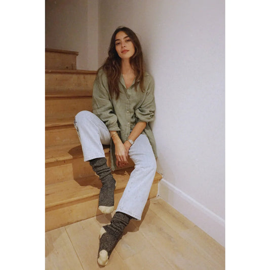 Frau auf Holzstufen in grünem Pullover und weißen Hosen, Bluse Palma | Sage
