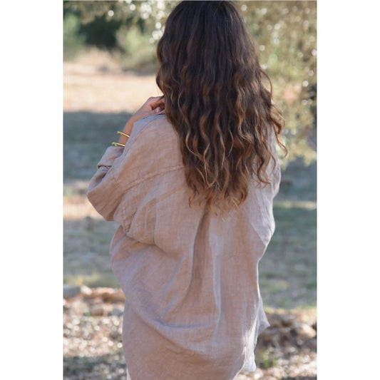 Frau mit langen, gewellten braunen Haaren trägt eine lockere, helle Bluse Palma Taupe