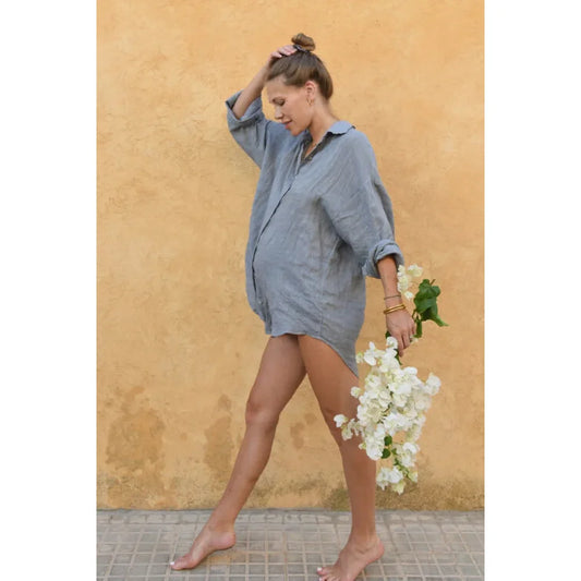 Schwangere Person in übergroßer blauer Bluse hält weiße Blumen, Bluse Palma von Yoli