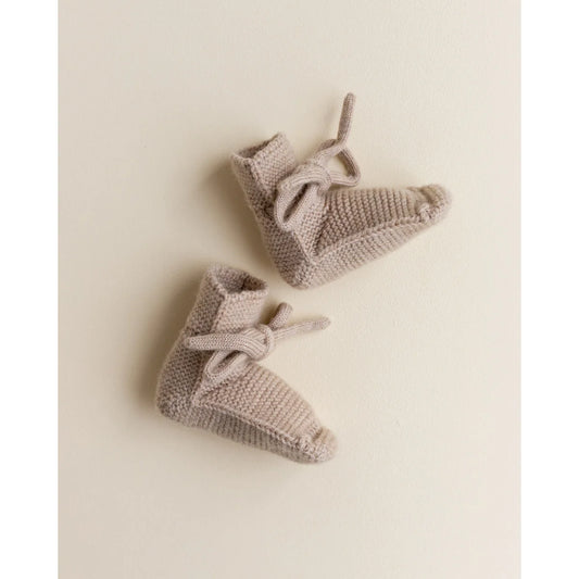 Paar gestrickte Babybooties mit Schleifen in Sandfarbe