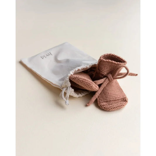 Paar handgestrickte Babybooties in staubrosa für ökologische Kinderbekleidung