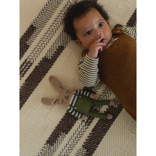 Gestricktes braunes Hasen-Spielzeug mit olivgrünen Overalls