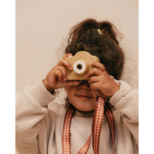 Holzspielzeugkamera mit Linse, gehalten vor dem Gesicht einer Person, Cam Cam Digitalkamera