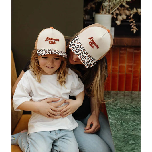 Creamfarbene trucker cap mit leo-print schirm und orange besticktem dreamers club schriftzug