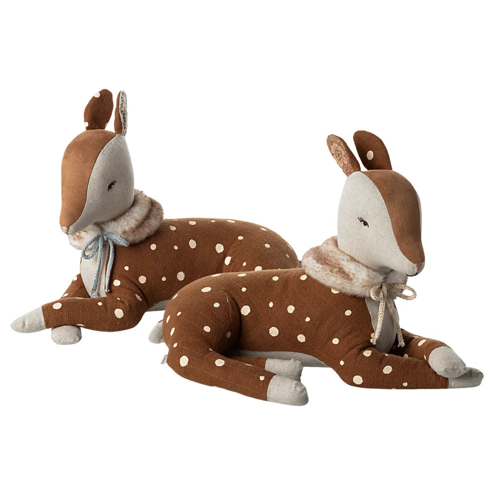 Zwei gepunktete braune Plüschhirschspielzeuge mit Schals liegen gemütlich da