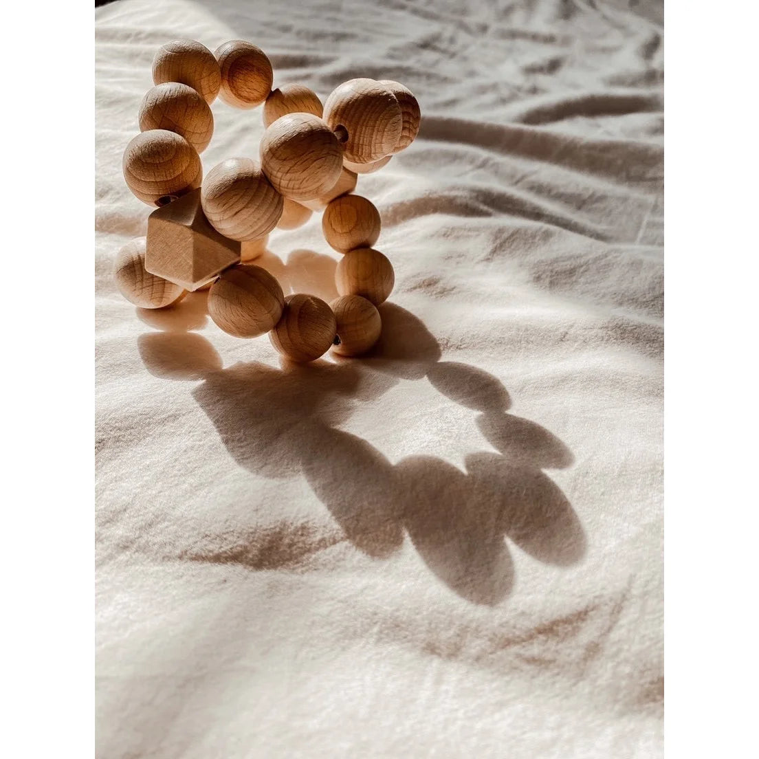 Holzperlen im Kreis angeordnet, werfen Schatten für das Produkt Cross Ball