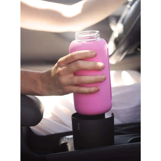 Eine Hand hält ein Glasgefäß mit leuchtend roter Flüssigkeit im Cup Holder Adapter