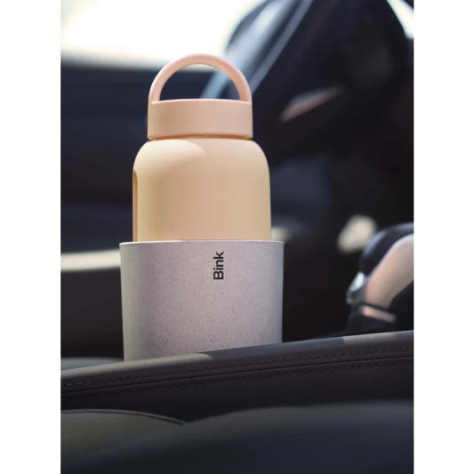 Beige Wasserflasche mit pinkem Griff in grauem Halter für Becherhalteradapter