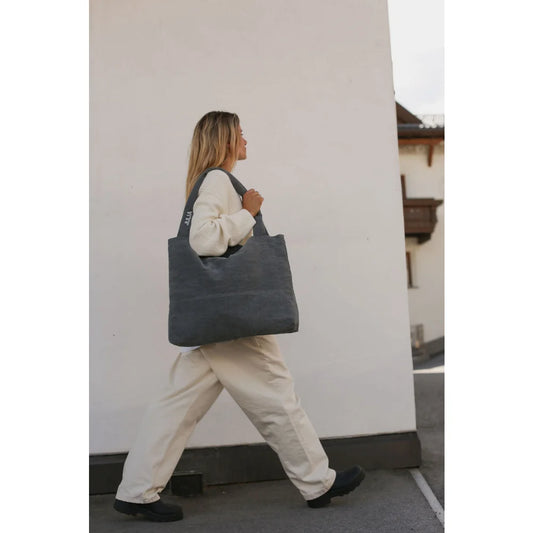 Frau trägt eine dunkelgraue Wickeltasche mit zwei Schultergurten, Denim Diaper Bag Grey