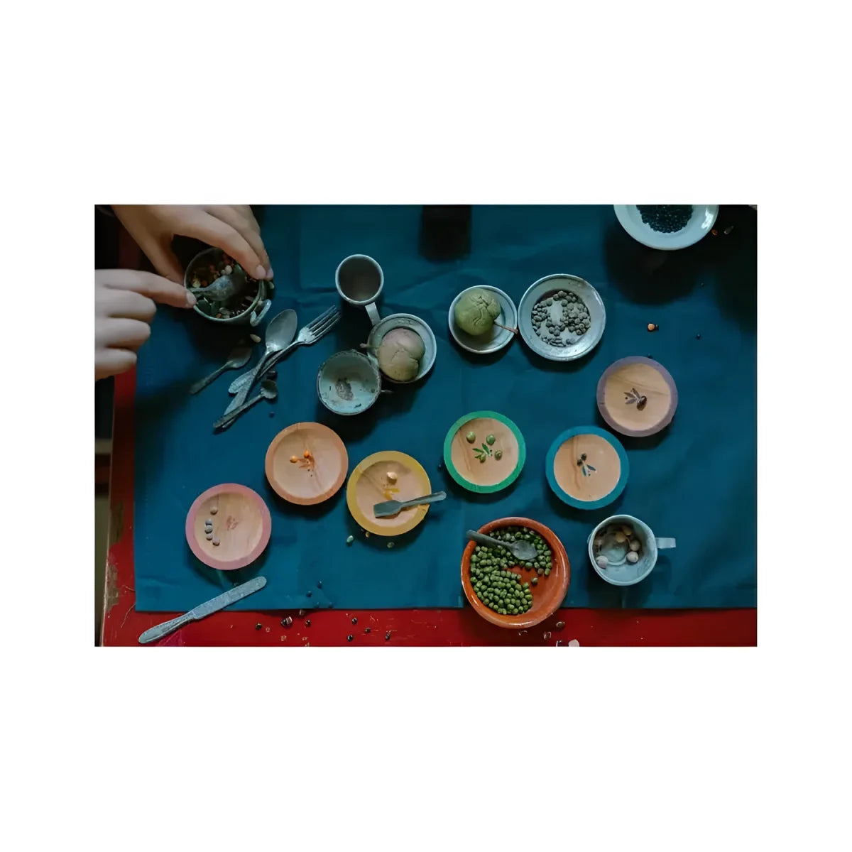 Eine sammlung bunter keramikschalen und metalltassen mit verschiedenen samen auf blauem untergrund