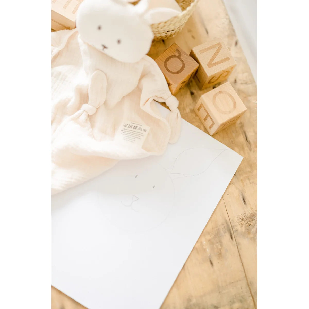 Leere weiße Notizkarte neben Doudou Hase für die Schwangerschaftsbola