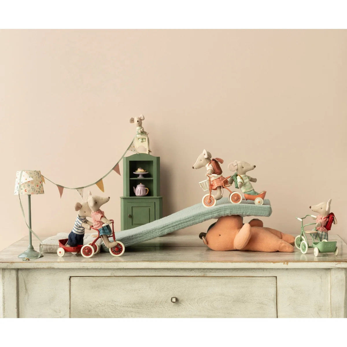 Verspielt inszenierte Spielzeugmäuse auf einer Kommode für Dreirad Anhänger Maus
