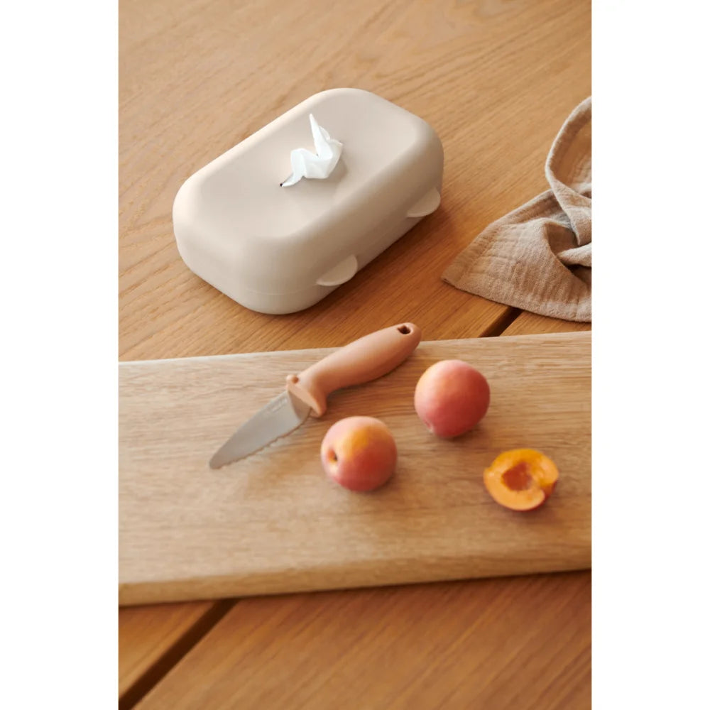 Pfirsiche und Messer auf Schneidebrett neben Feuchttuch-Behälter Emi Sandy