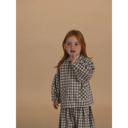 Junge Frau mit langen rotbraunen Haaren trägt Gingham Lodge Shirt und passende Hose