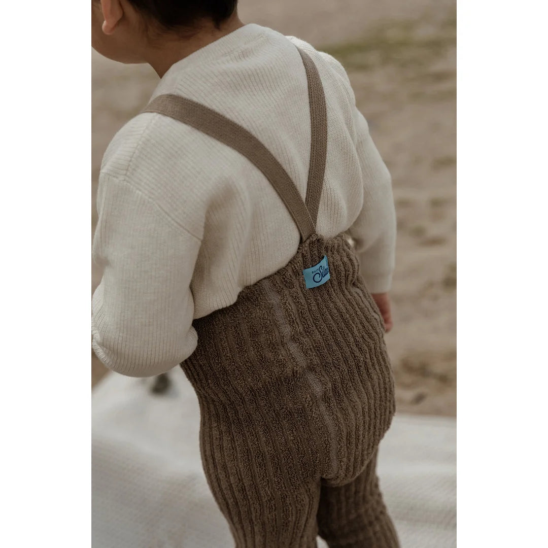 Braune Strampler mit Trägern über einem weißen Pullover in Oyster Grey