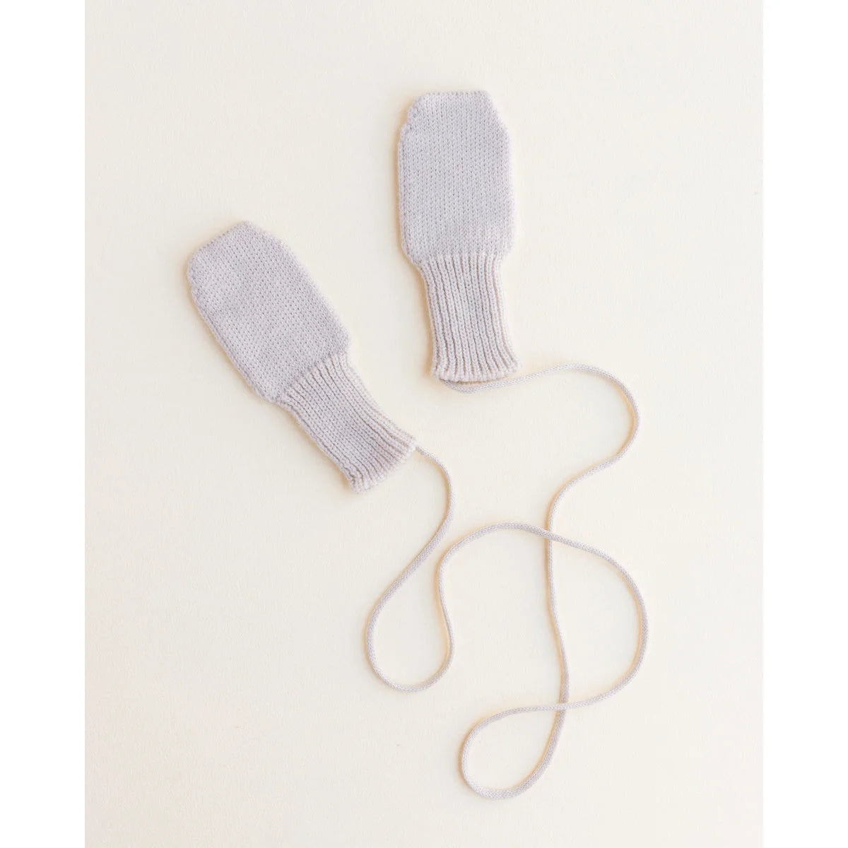 Helle graue gestrickte Babymitten mit angehängten Schnüren als Handschuhe in Off-white