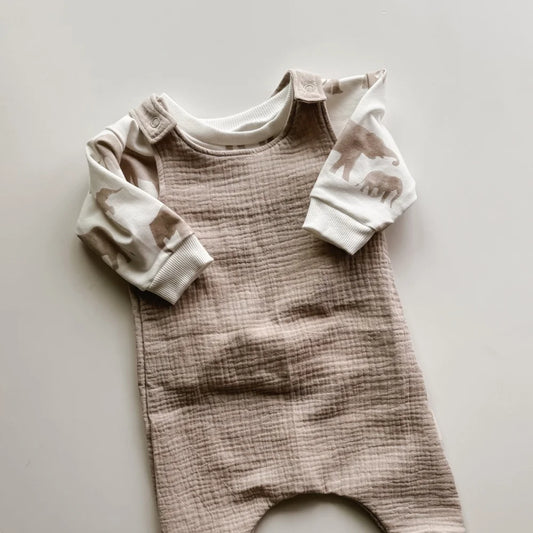 Baby romper in beige with white sleeves, ideal for stylish infant outfits