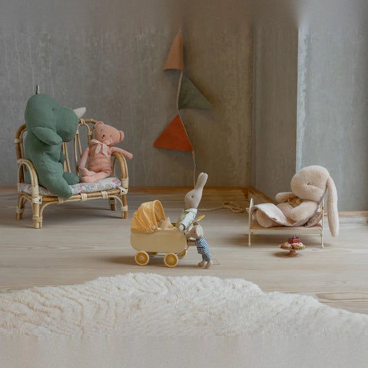 Maileg small plush rabbit in Latte in a doll's bed, scene with a doll's pram and soft toys