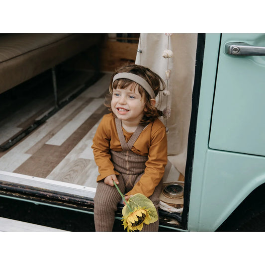 Lächelndes Kind mit Kopfhörern und Sonnenblume, Hippy Footless Strumpfhosen im Cocoa Blend