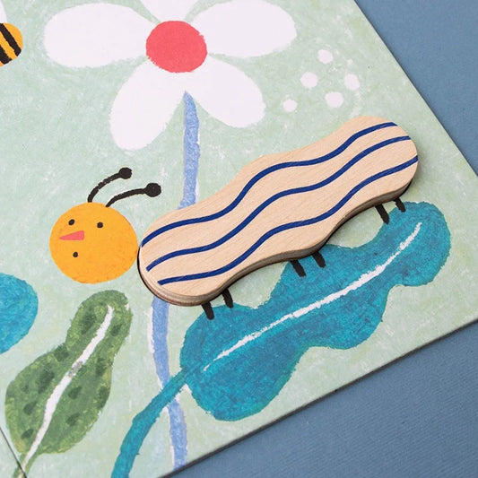 Gestreifter Raupe-ähnlicher Kreatur mit orangefarbigem Kopf neben einer weißen Gänseblümchen