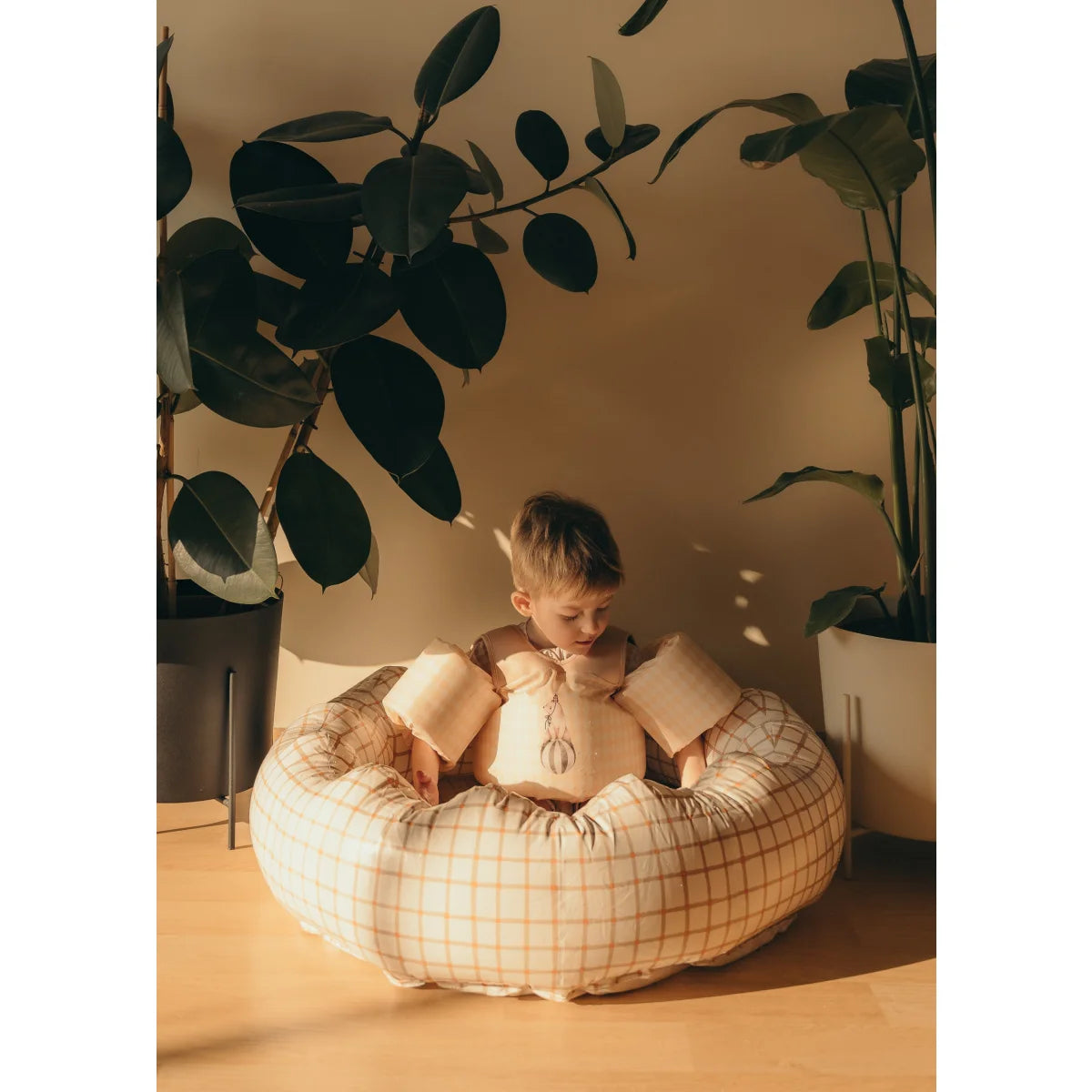 Kind in einem karierten aufblasbaren Pool-Float von Organic Squares