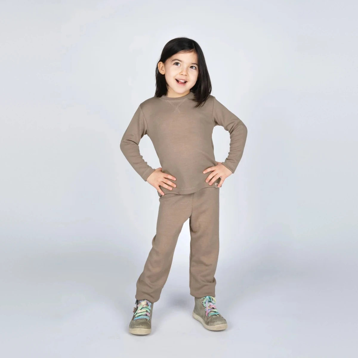 Bambina con completo felpa per bambini color sabbia con maglia a maniche lunghe e pantaloni