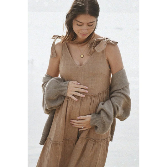 Schwangere Frau in einem beigen Kleid aus der Kollektion Kleid Sevilla | Rye
