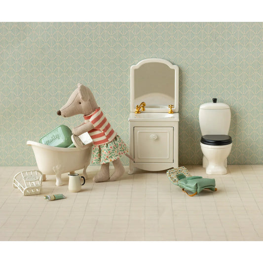 Ein plüsch maus-figürchen mit kleidungsset in rot-weiß gestreift und blumenrock neben mini badewanne geschenke für neugeborene