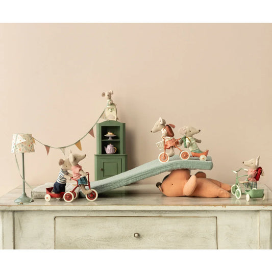 Verspielte Szenerie mit Spielzeugtieren und Miniaturmöbeln auf einer Kommode