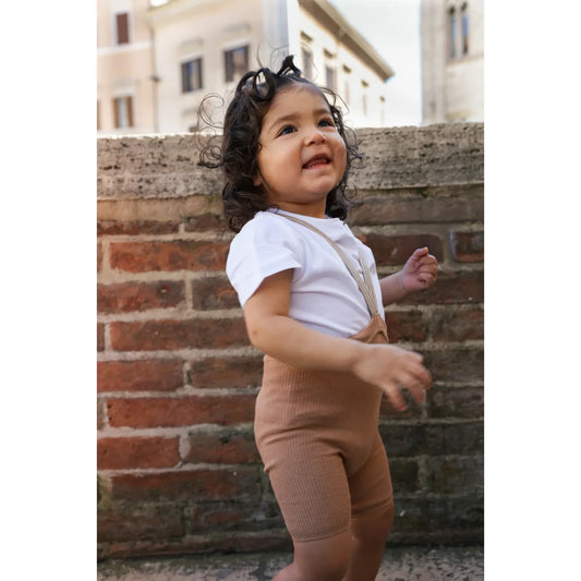 Kind trägt tanfarbene gerippte kurze strumpfhose mit trägern nachhaltige babykleidung schweiz ökologische baby- & kinderprodukte