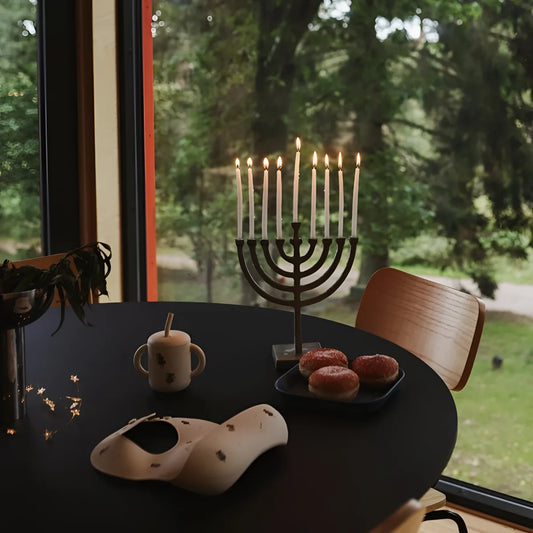 Ein schwarzer metall menorah mit neun weißen kerzen lit als geschenke für neugeborene ökologische babyprodukte