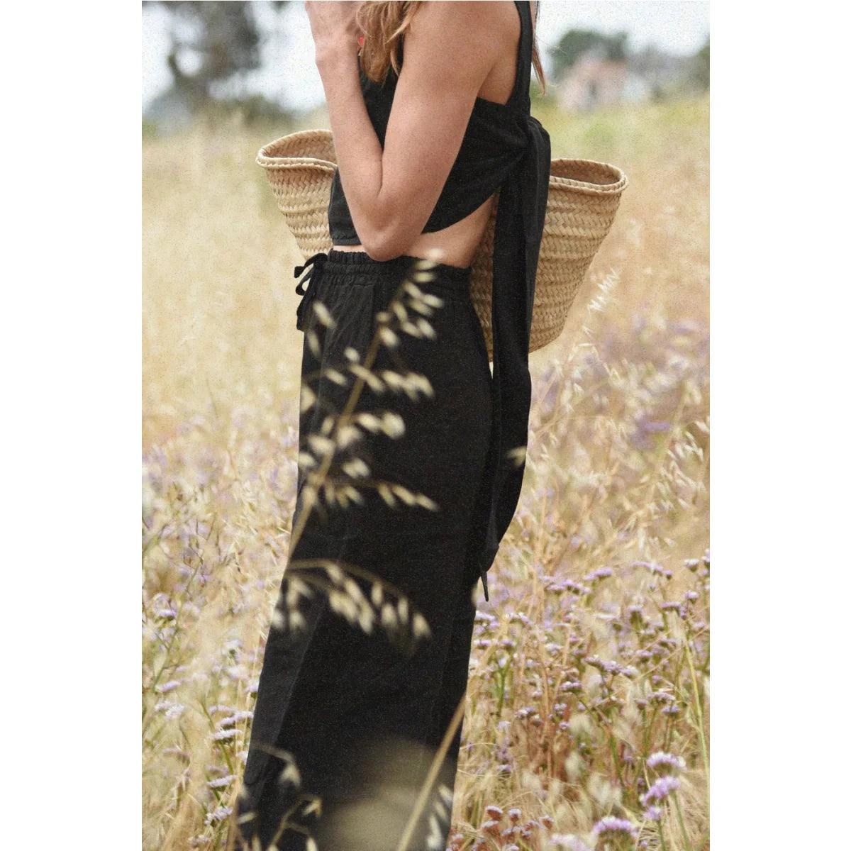 Frau in schwarzem Crop-Top und Hose mit Strohtasche, Leinen Hose Isla Noir