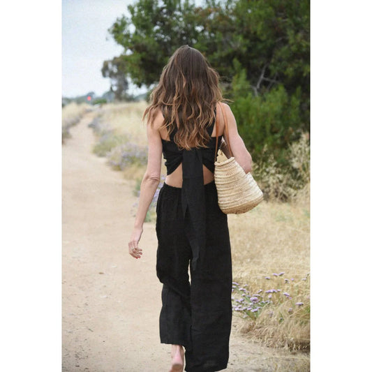 Dame Frau im schwarzen Jumpsuit mit Strohtasche präsentiert Leinen Hose Isla | Noir