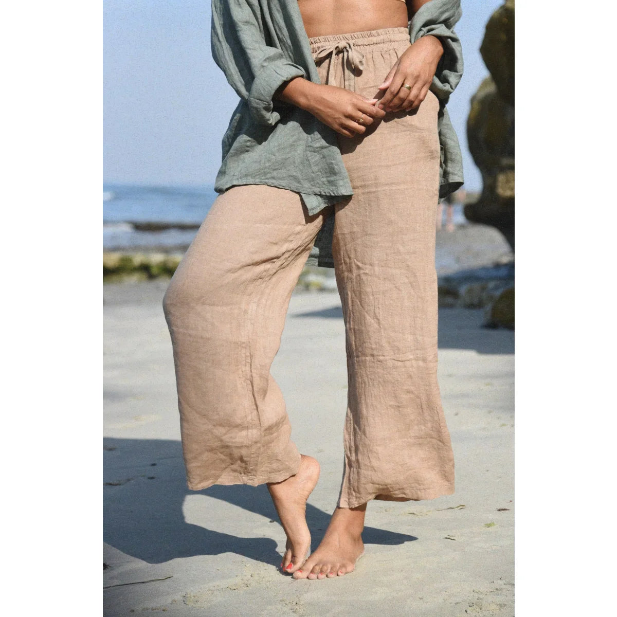 Beige Leinenhose Isla von Rye in weiter Beinform am Strand getragen