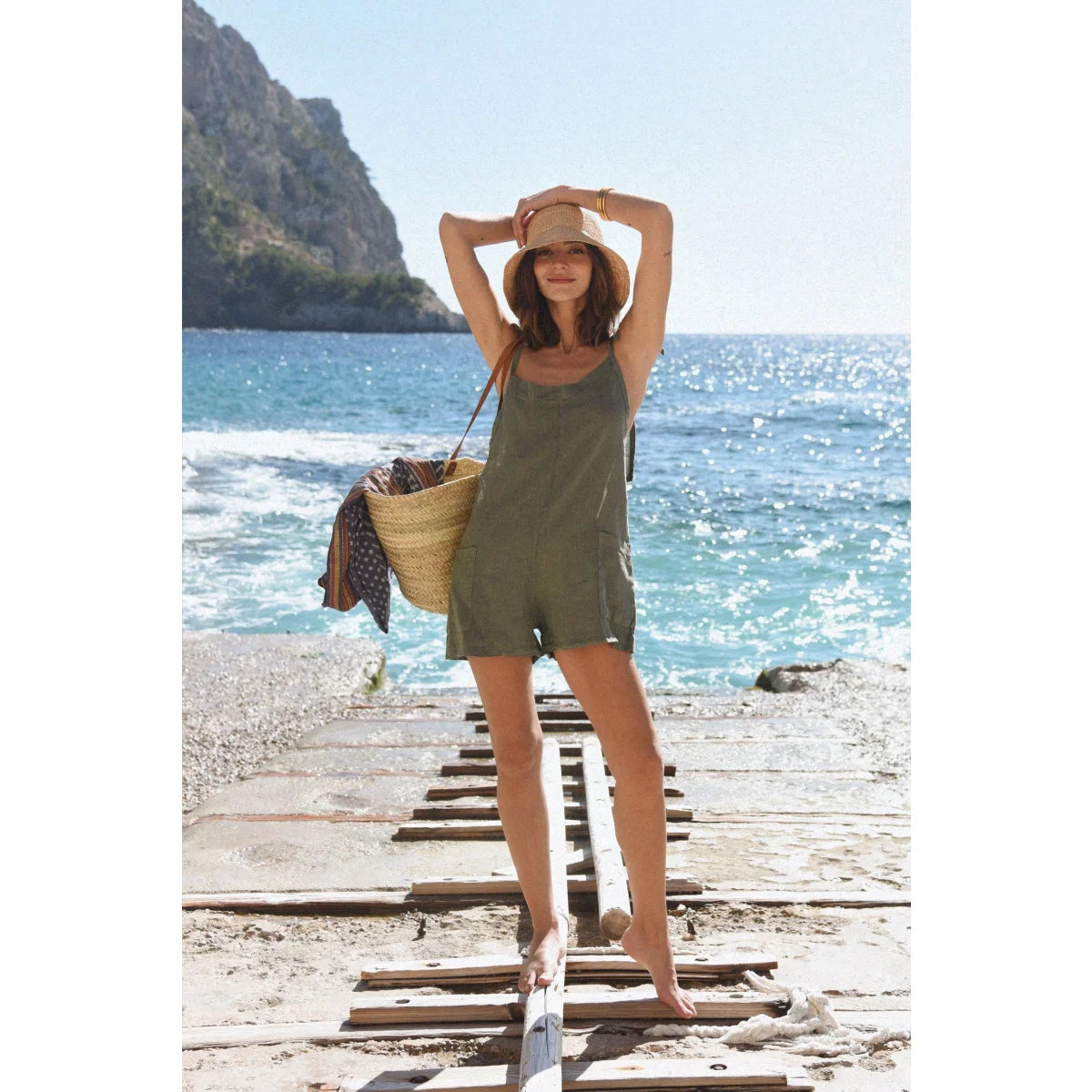 Frau im grünen Leinen Overall Verano kurz mit Strohhut