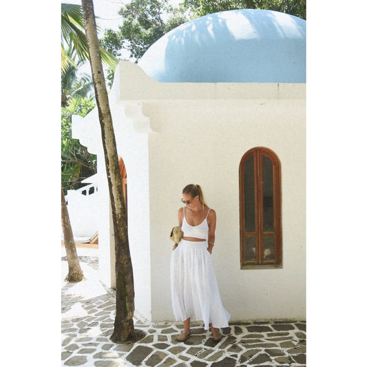 Frau in weißem zweiteiligem Outfit für den Leinen Rock Alba Blanco