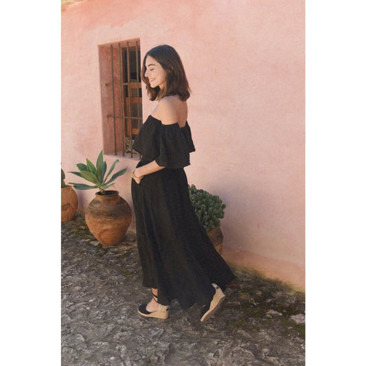 Frau in Off-Shoulder-Schwarzes Leinenrock Alba Noir vor stiligem Hintergrund